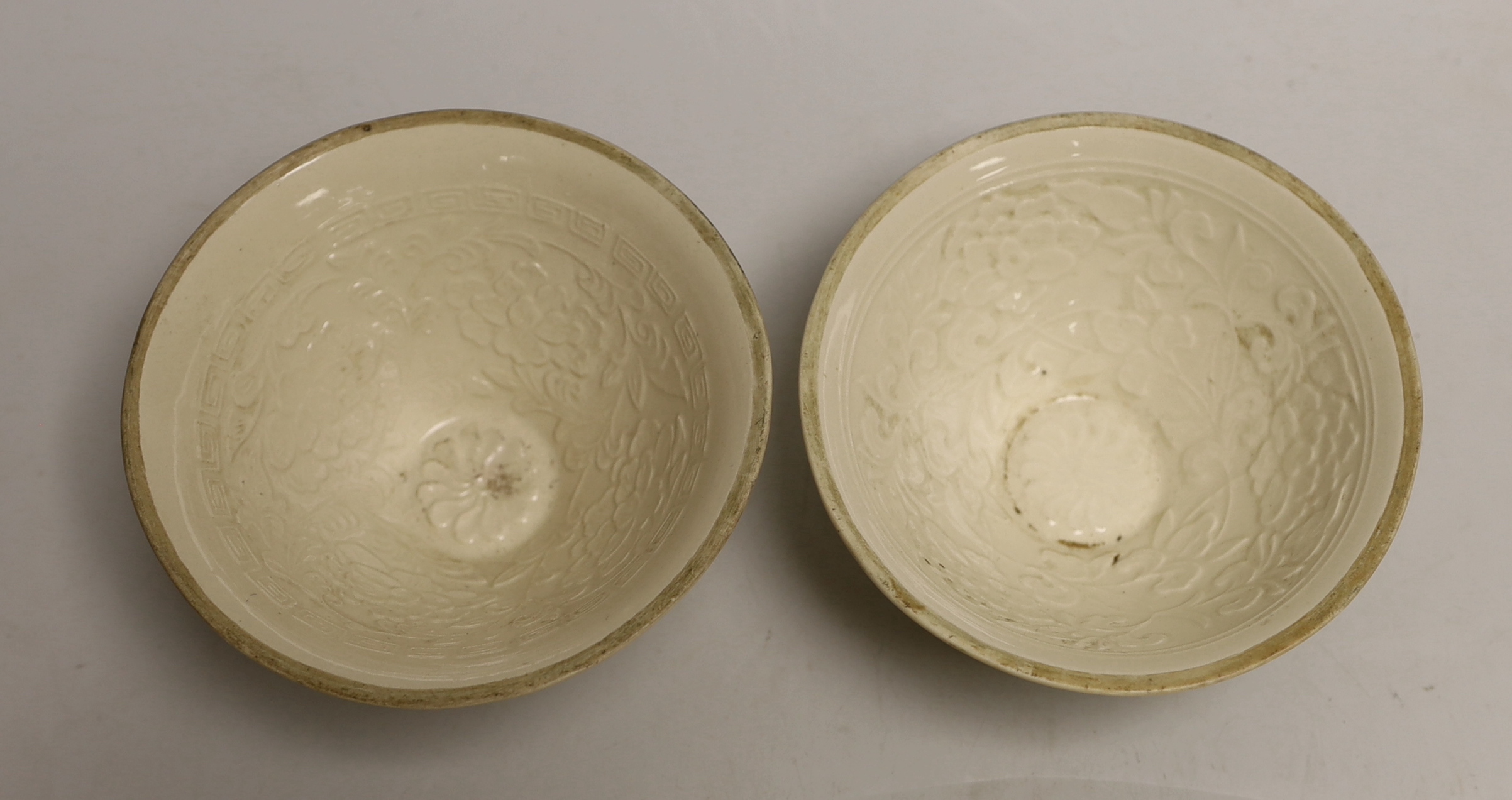 A pair of Chinese Ding type relief moulded bowls, 12cm in diameter